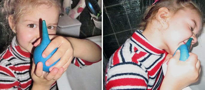 Маленькая девочка промывает нос спринцовкой